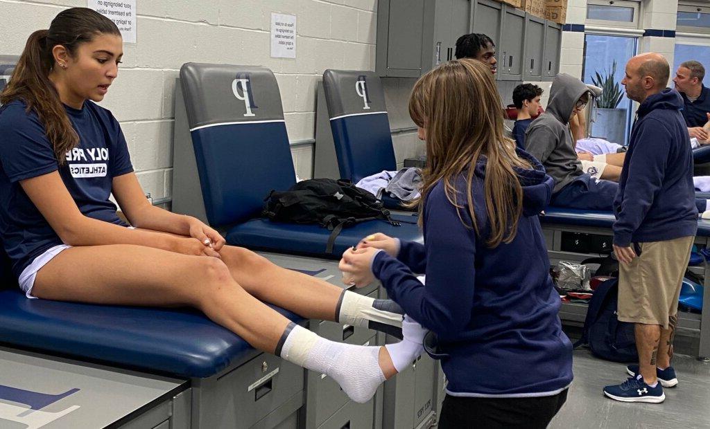 Athletic Trainer Alyssa Alaimo works on student's ankle